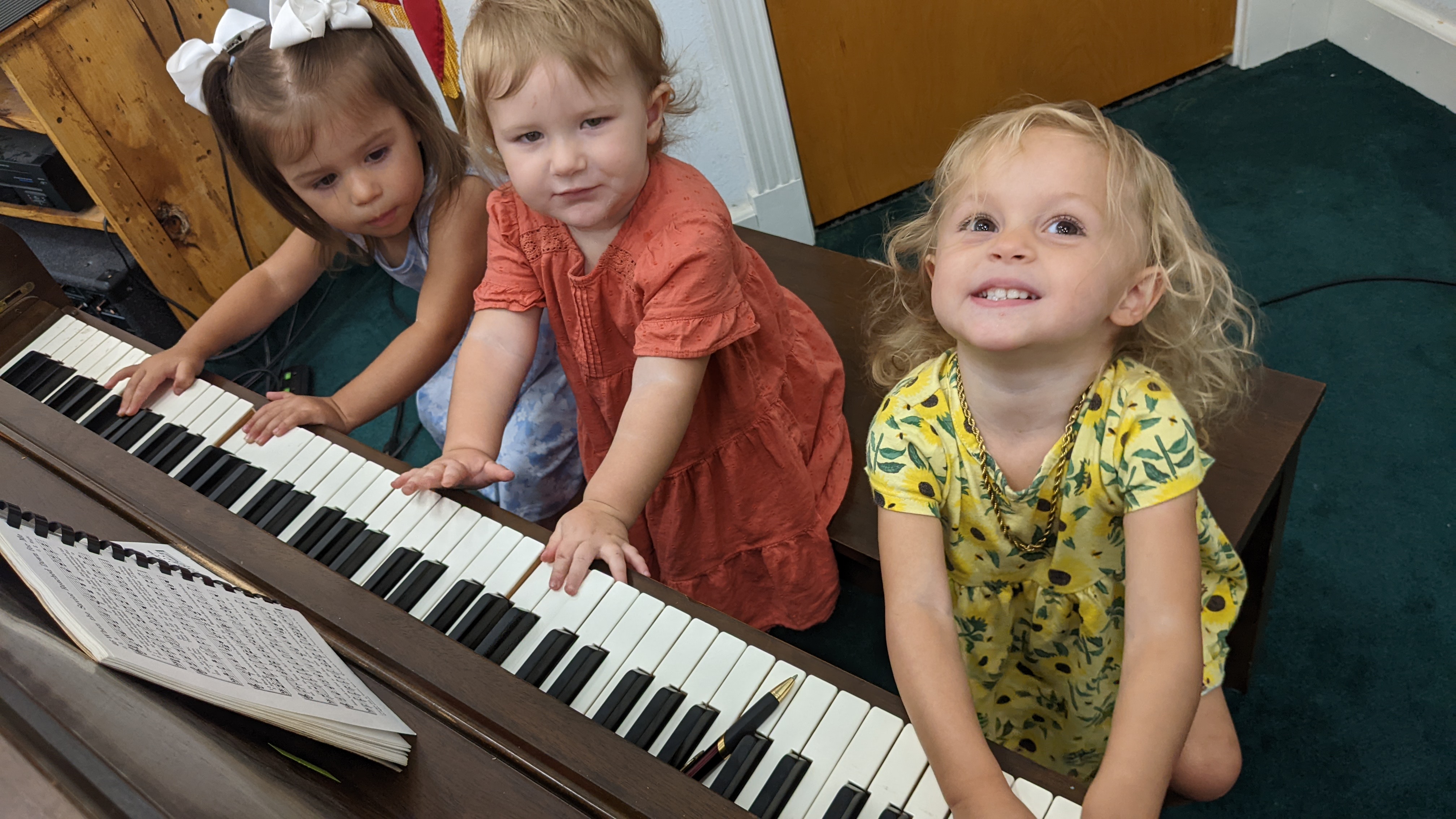 Three toddlers playing the church piano.